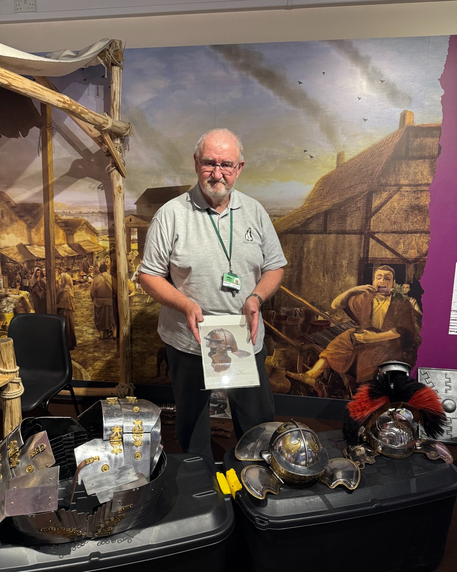 a photo of a man showing off roman helmets